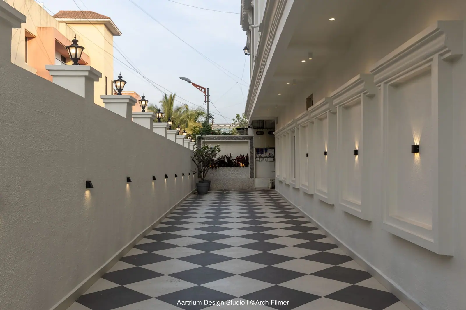 Side passage — a checkerboard walkway framed by moulded panelling and wall washers.