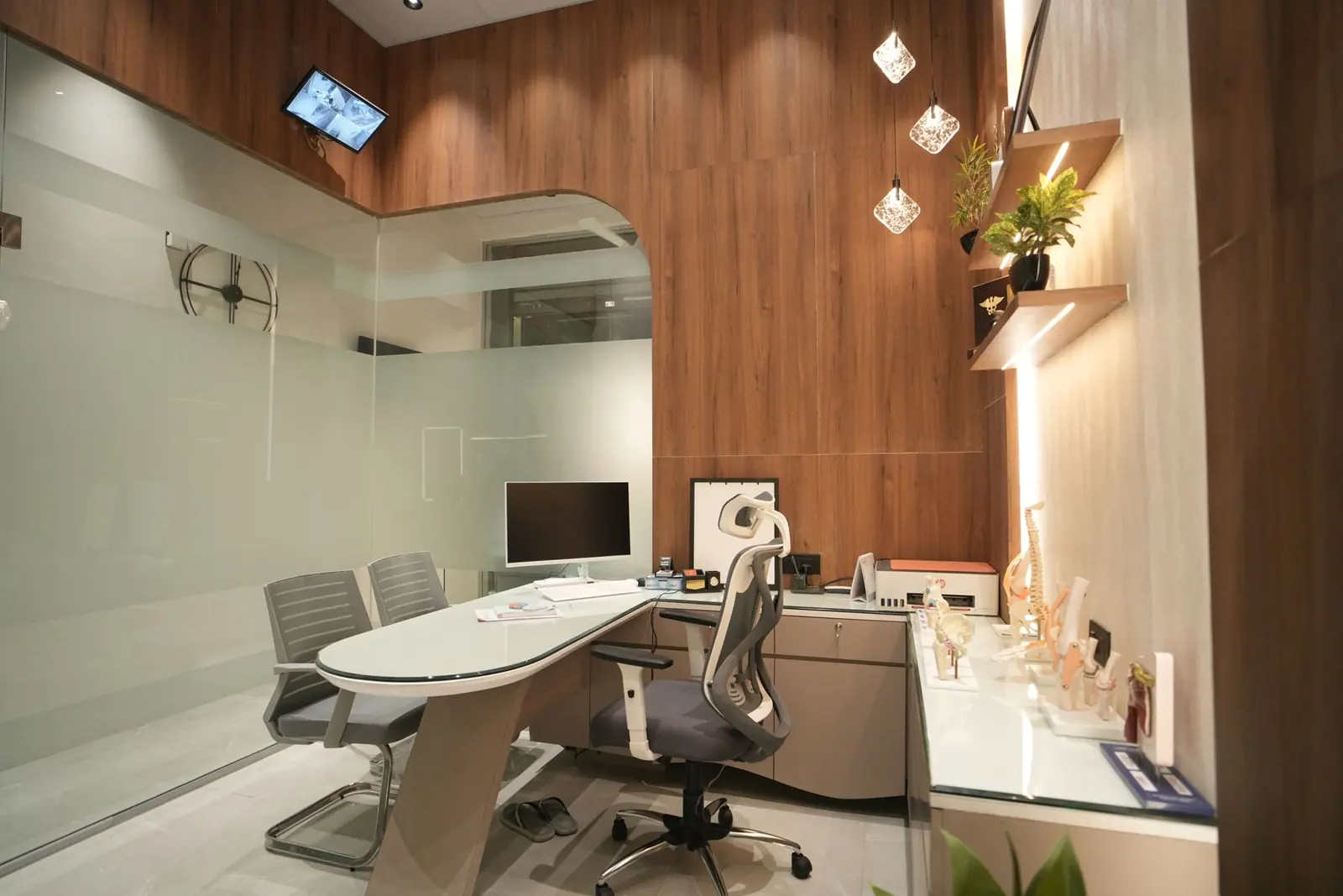 Consulting cabin — the doctor's desk and dental unit seen through a frosted glass partition.