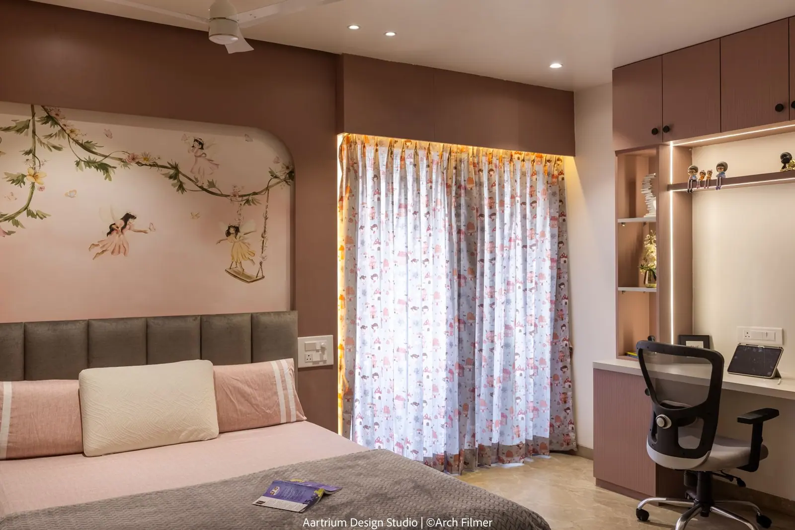 Bedroom — the mural headboard wall with a corner study desk and overhead storage.