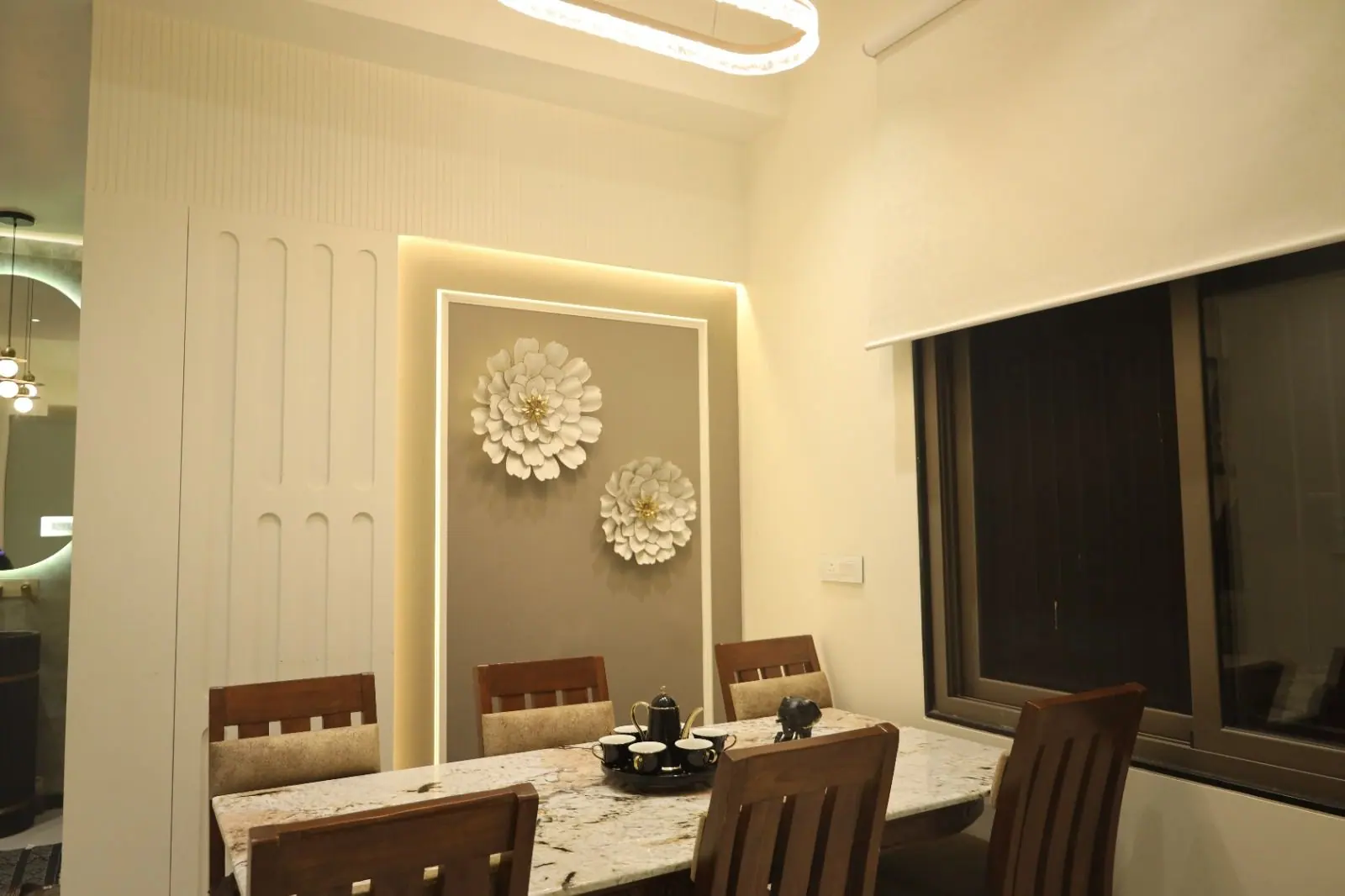 Dining — a marble-top table beside a fluted panel with floral wall art.