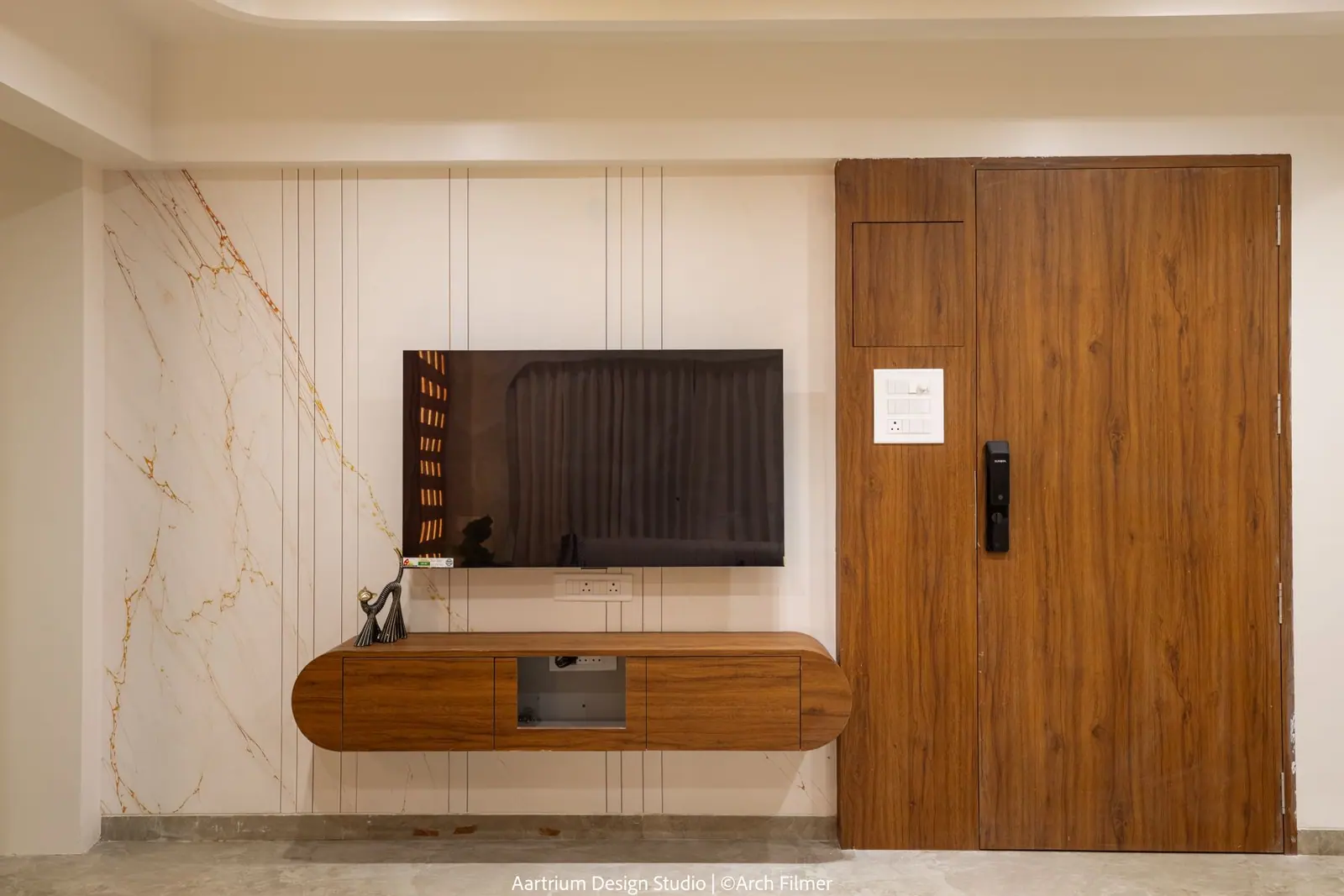 Entrance foyer — a marble-veined TV wall meeting the timber main door.