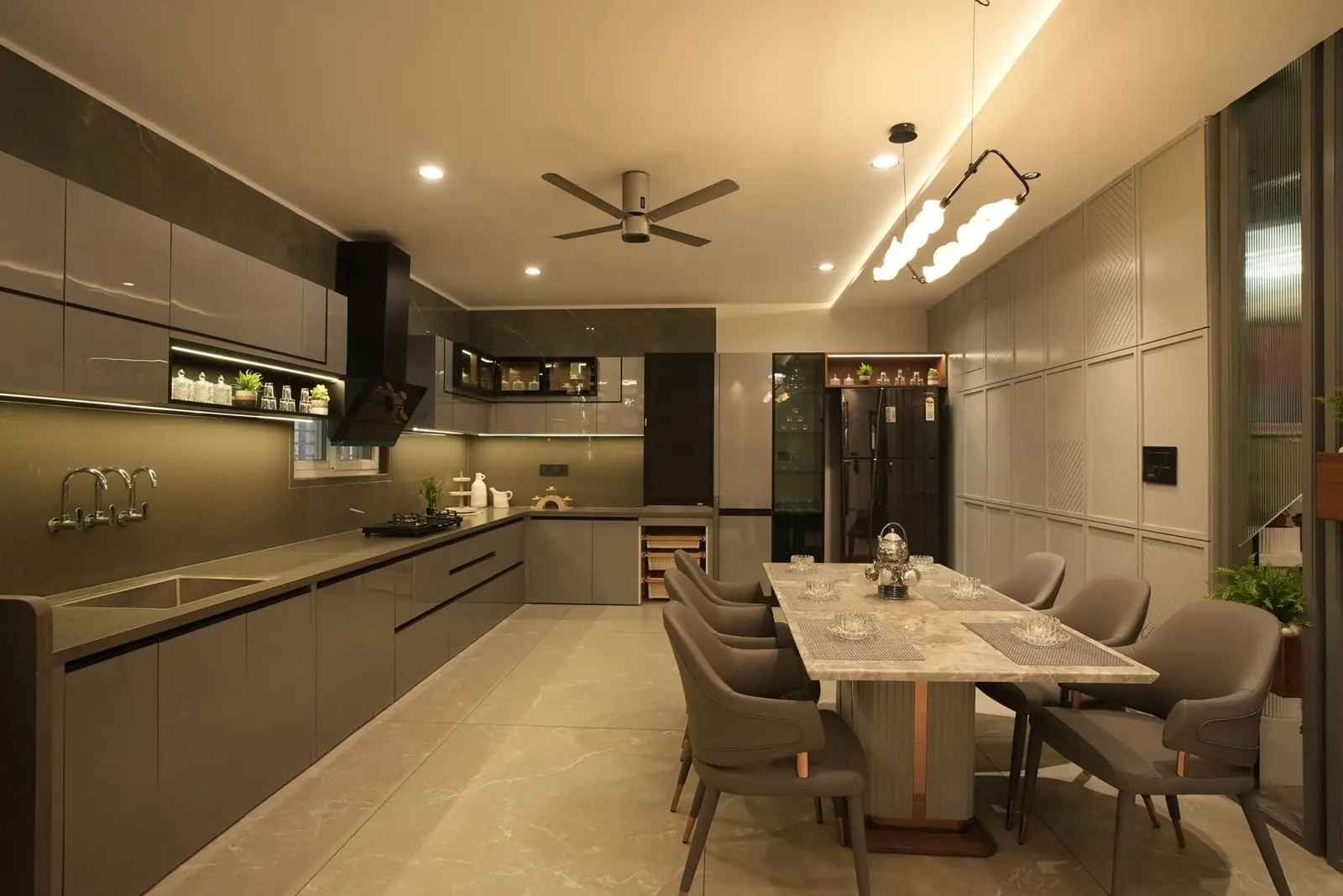 Kitchen and dining — a linear grey modular kitchen opening onto the dining table.