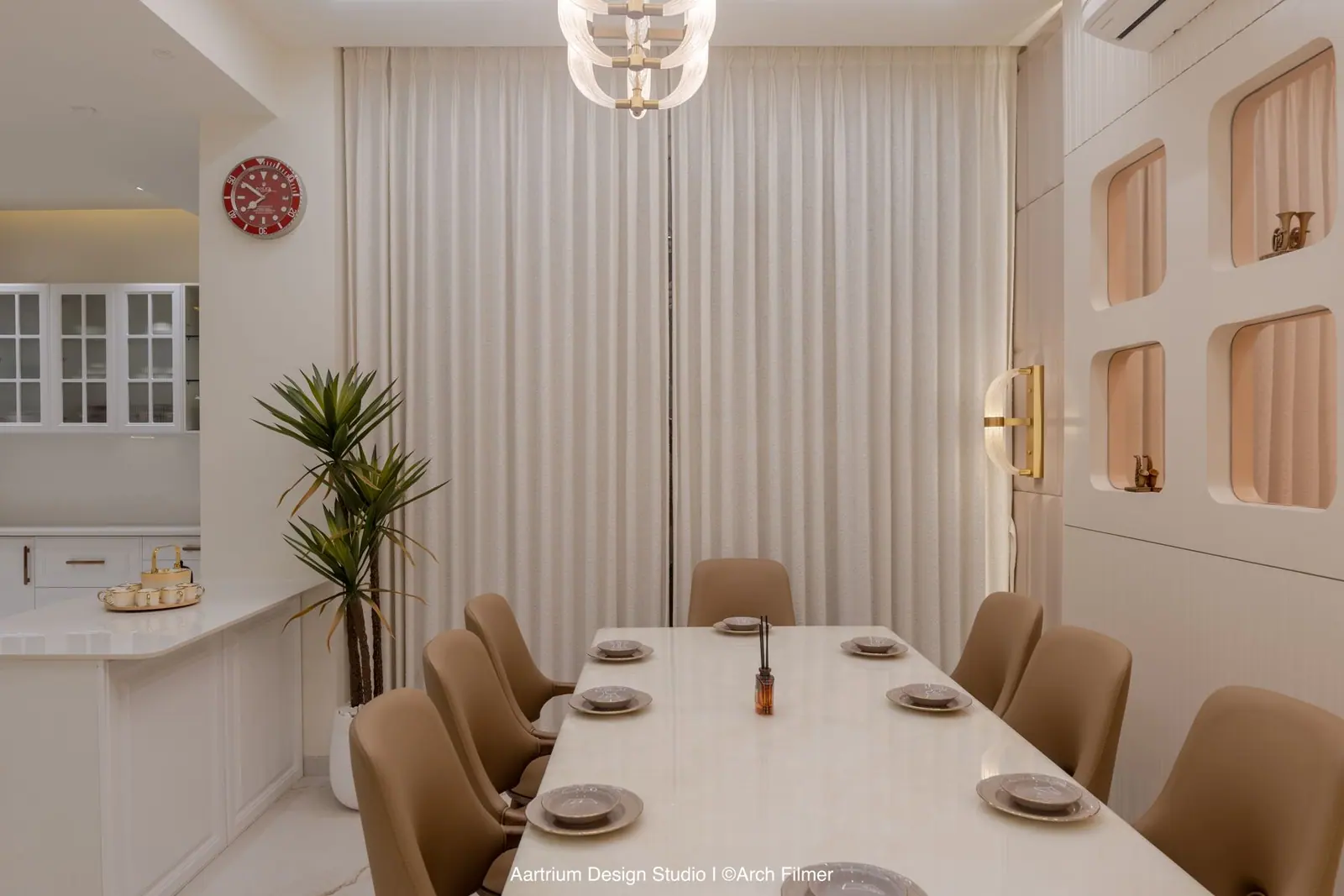 Dining — drape-lined walls, arched display niches and a long table under a glass pendant.