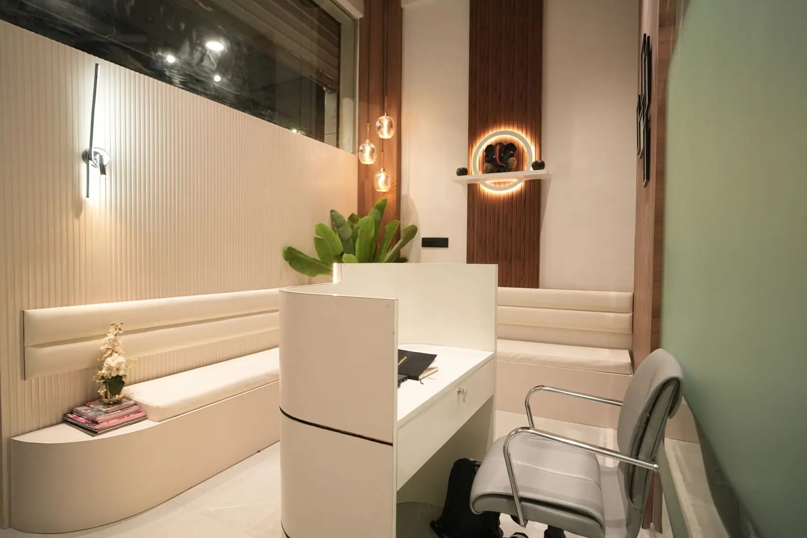 Reception — a curved white counter beside the waiting bench and brand niche.