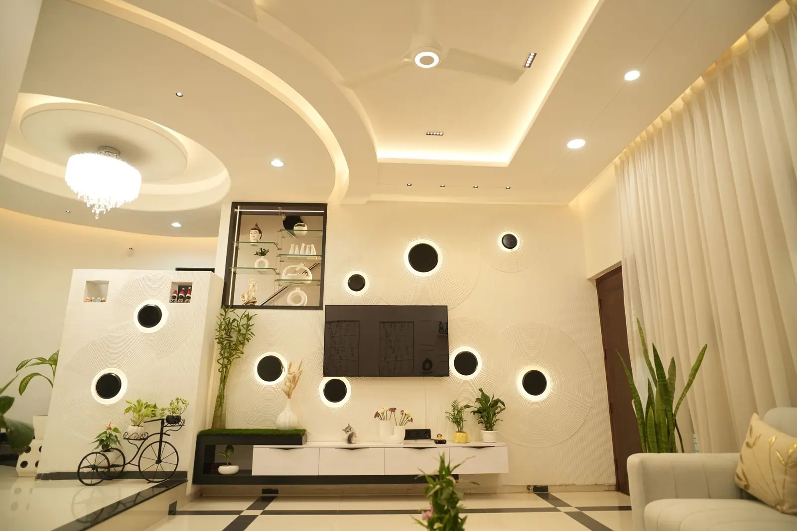 Living room — the media wall with circular niches, planting and a low console.