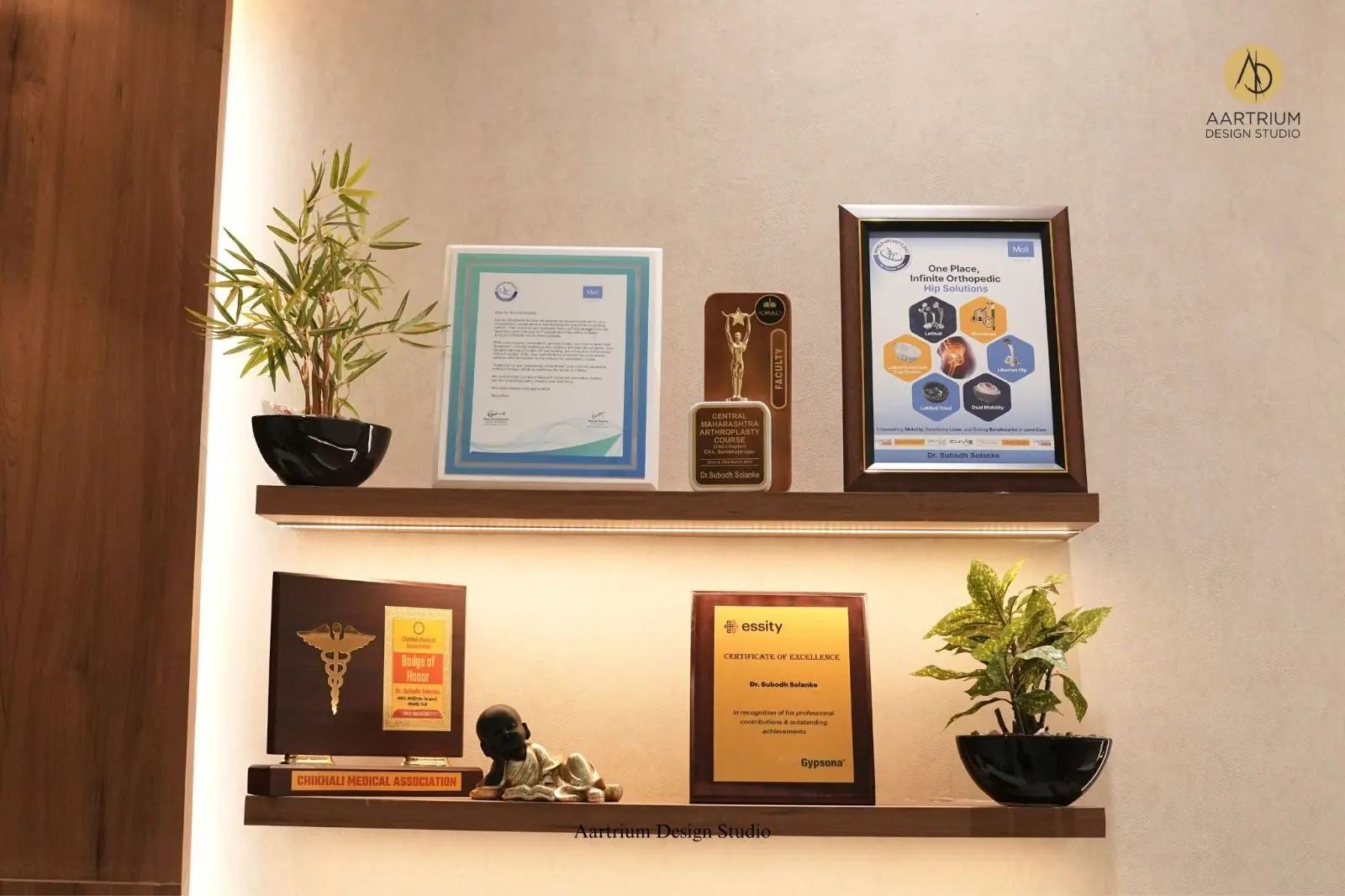 Awards wall — framed accreditations and trophies on floating walnut shelves.
