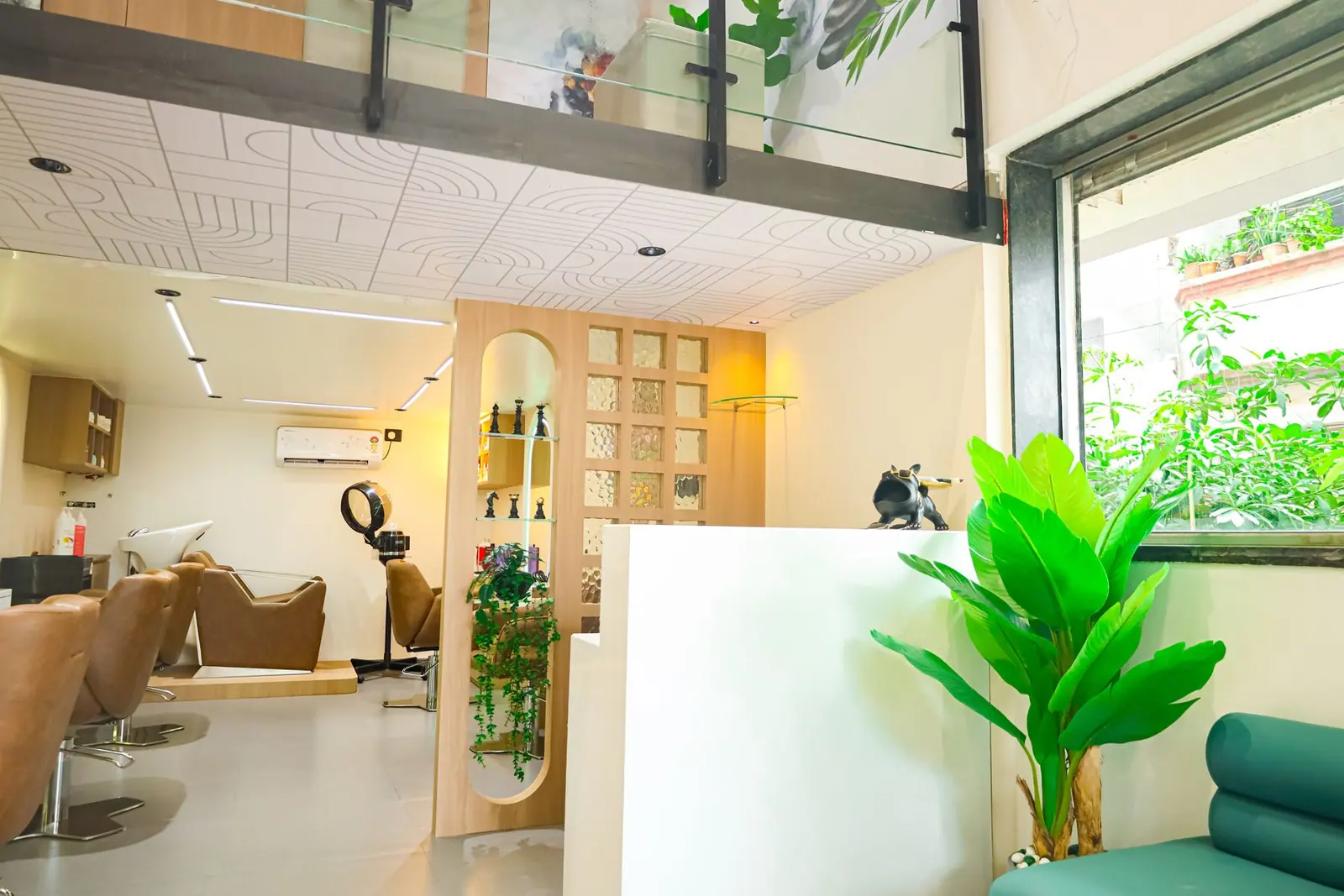 Wash area — shampoo stations beside a frosted partition and a green window bench.