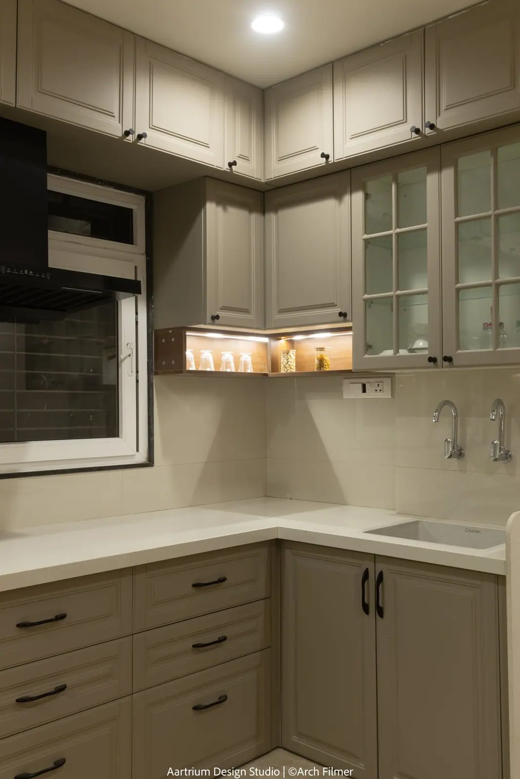 Kitchen — a compact olive-grey shaker kitchen with a window over the sink.