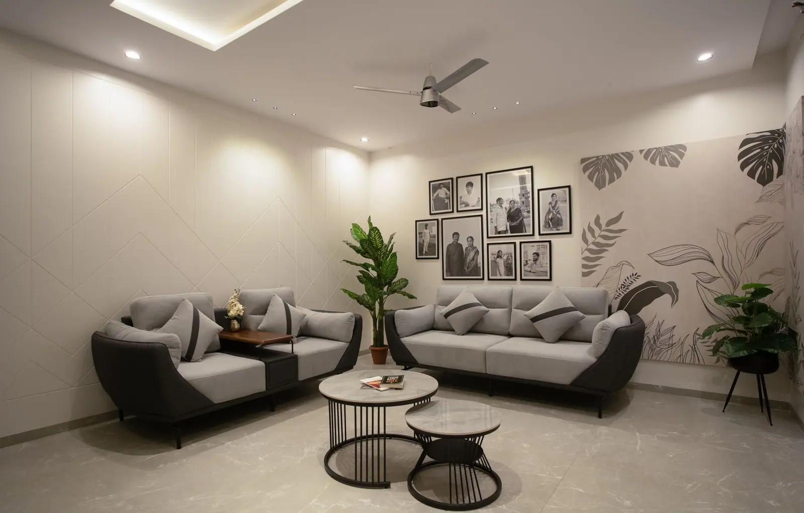 Family lounge — grey sofas, a framed gallery wall and a hand-painted botanical mural.